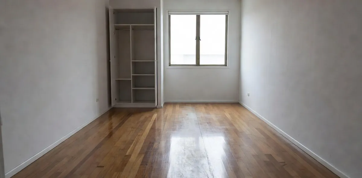 An apartment bedroom floor with a dull worn path from the door to the window